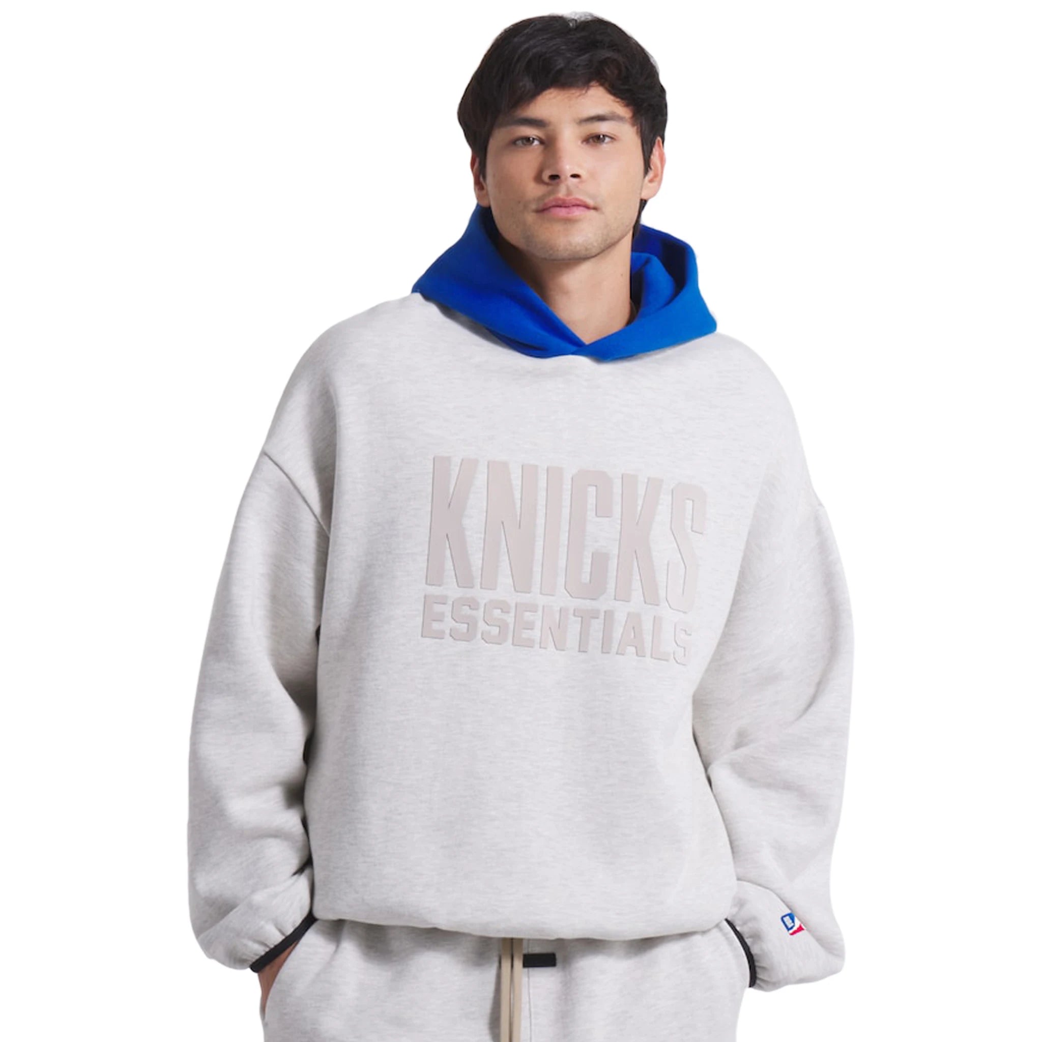 Model front view of Fear Of God Essentials x Knicks Light Heather Hoodie