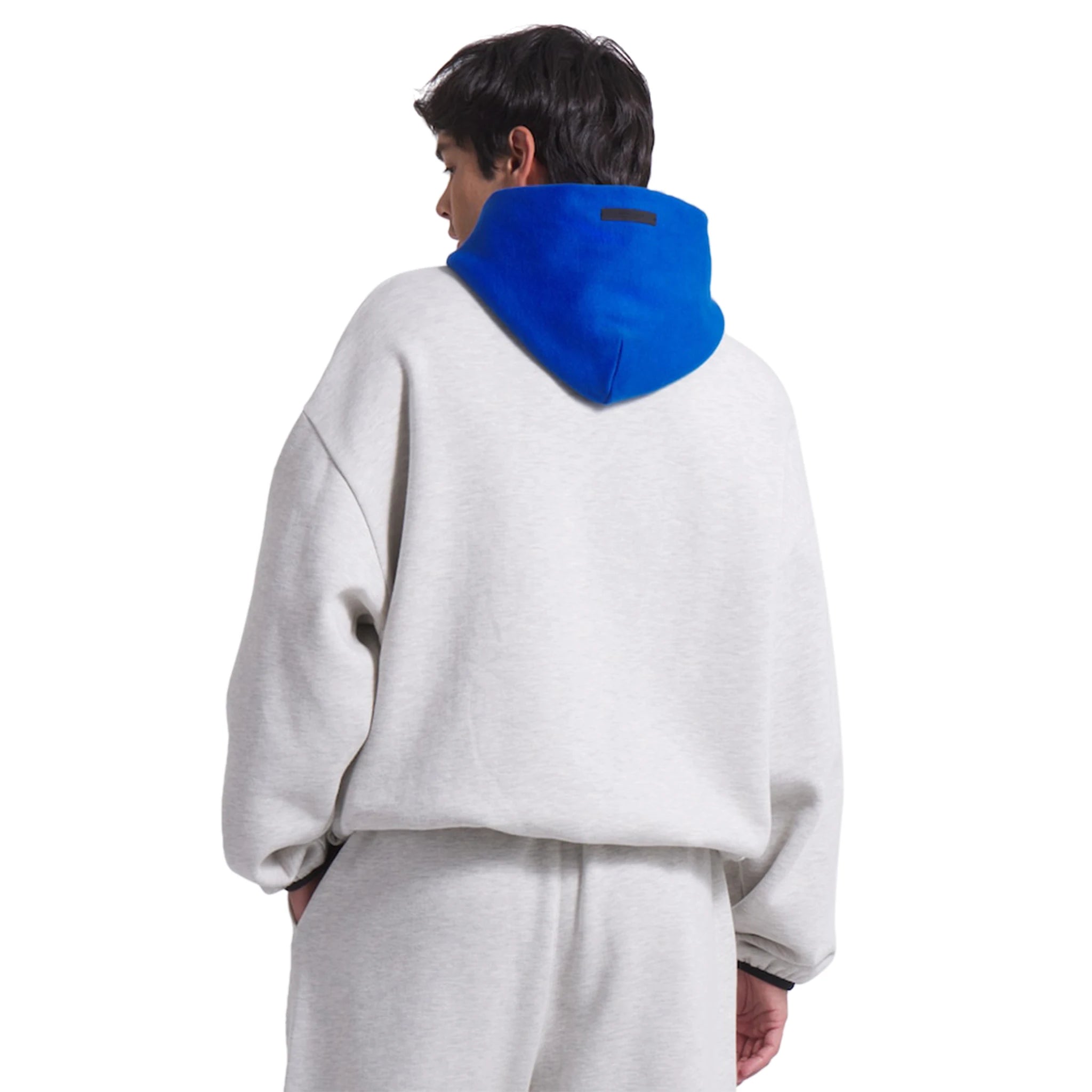 Model back view of Fear Of God Essentials x Knicks Light Heather Hoodie