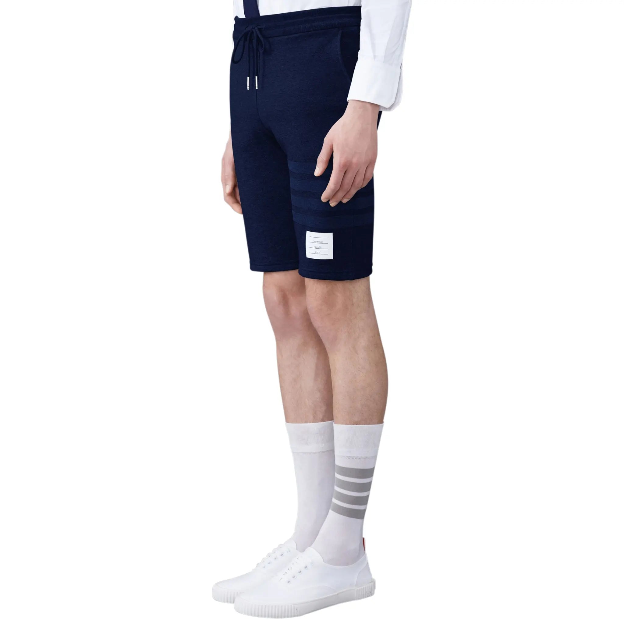 Model side view of Thom Browne Classic Loopback 4-Bar Blue Sweat Shorts MJQ012A-06910-415