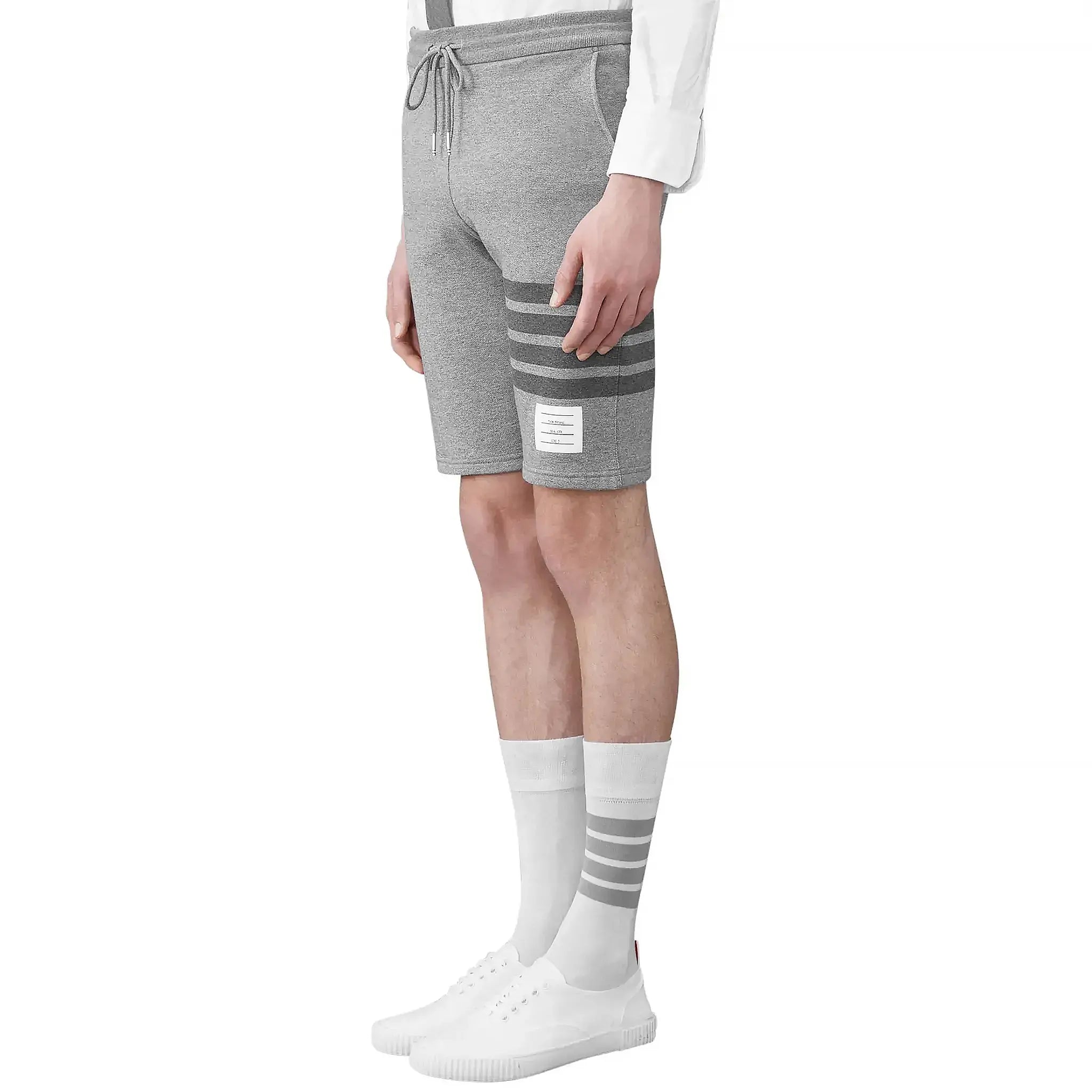 Model side view of Thom Browne Classic Loopback 4-Bar Grey Sweat Shorts MJQ012H-00535-068